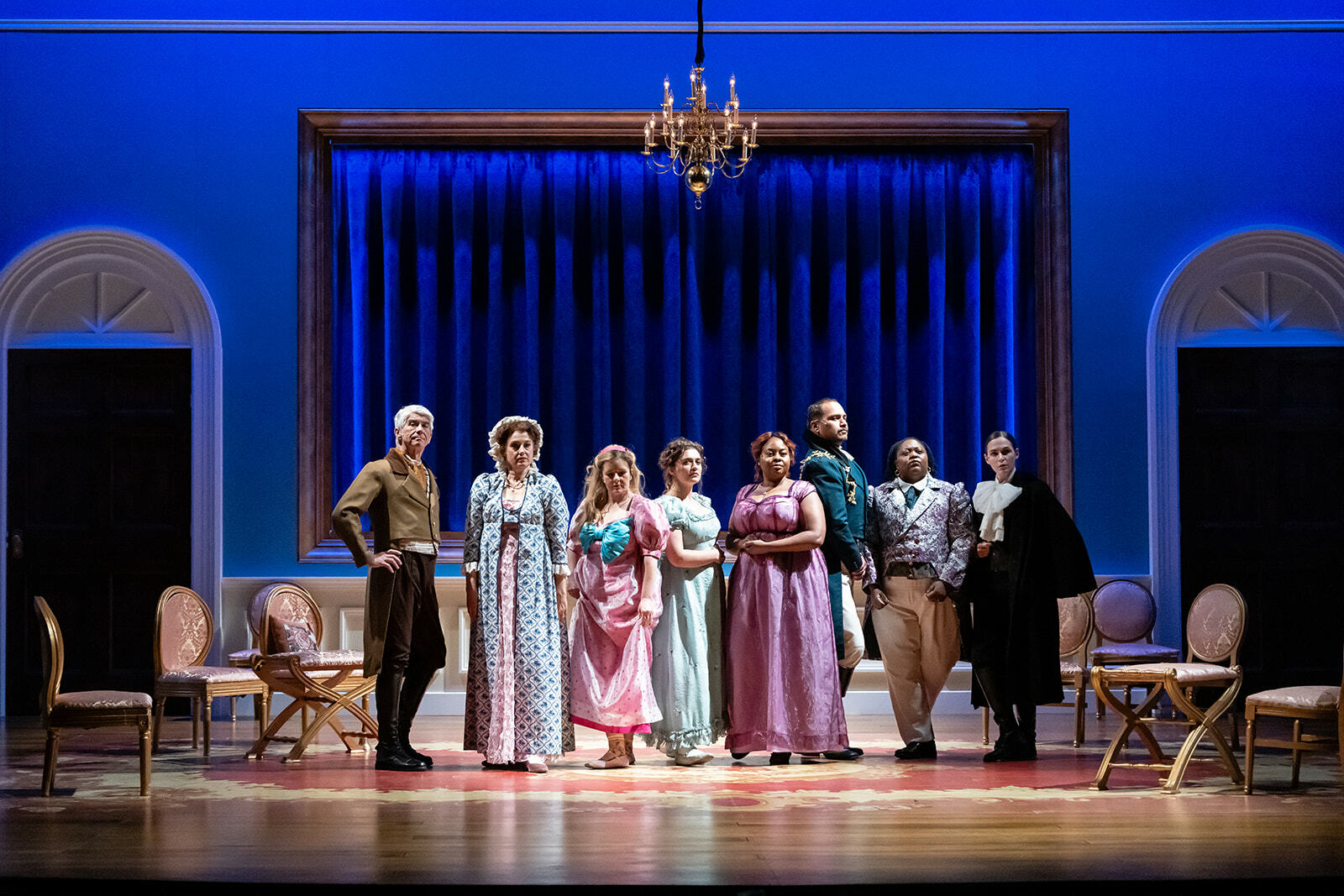 Cast of Pride and Prejudice in costume standing in a line across the stage.