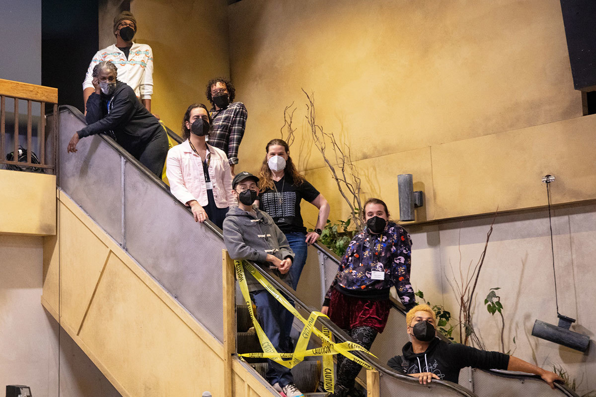 The cast and select creative team members of Hedwig posing on the set's escalator.