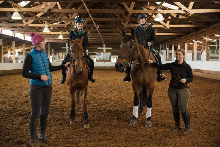 l-r: Trainer Rebecca Buehler, Lexi Lapp on Butter the horse, Alex J. Gould on Chiron the horse, and trainer Alishia Cook in the indoor arena at Farmhill Equestrian Center.