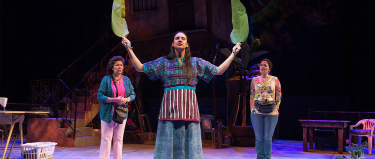 Medea (Sabina Zuniga Varela, center) holds banana leaves up to the sky as she whispers a prayer. Tita (VIVIS, left), and Josefina&nbsp;(Nancy Rodriguez, left) look on.