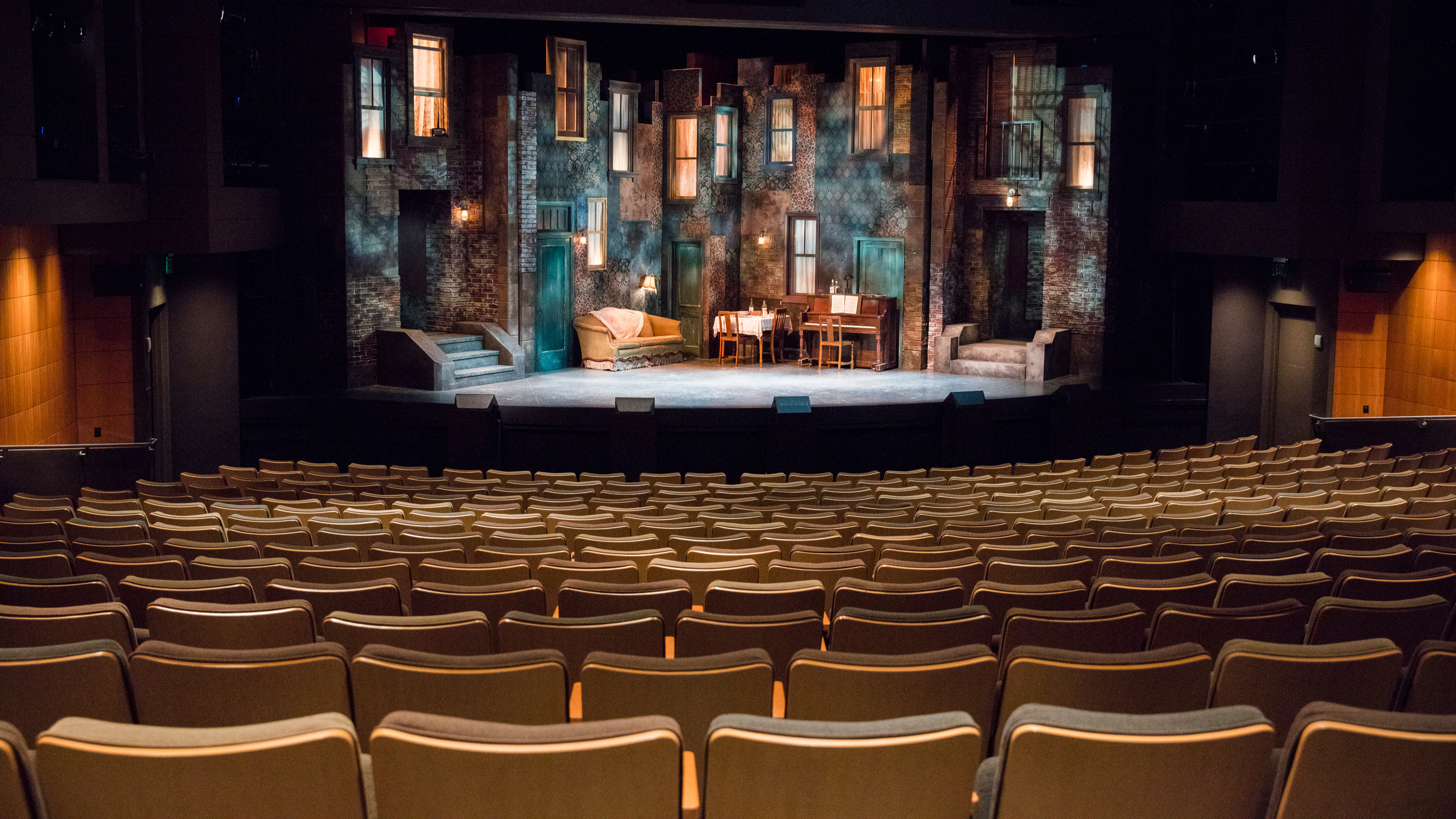 main stage theater seats looking down to the stage with a couch on stage