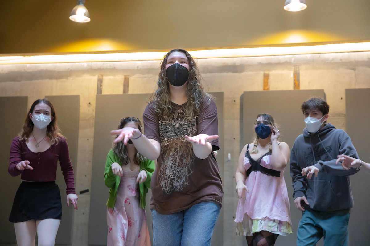A group of students performing a musical scene.