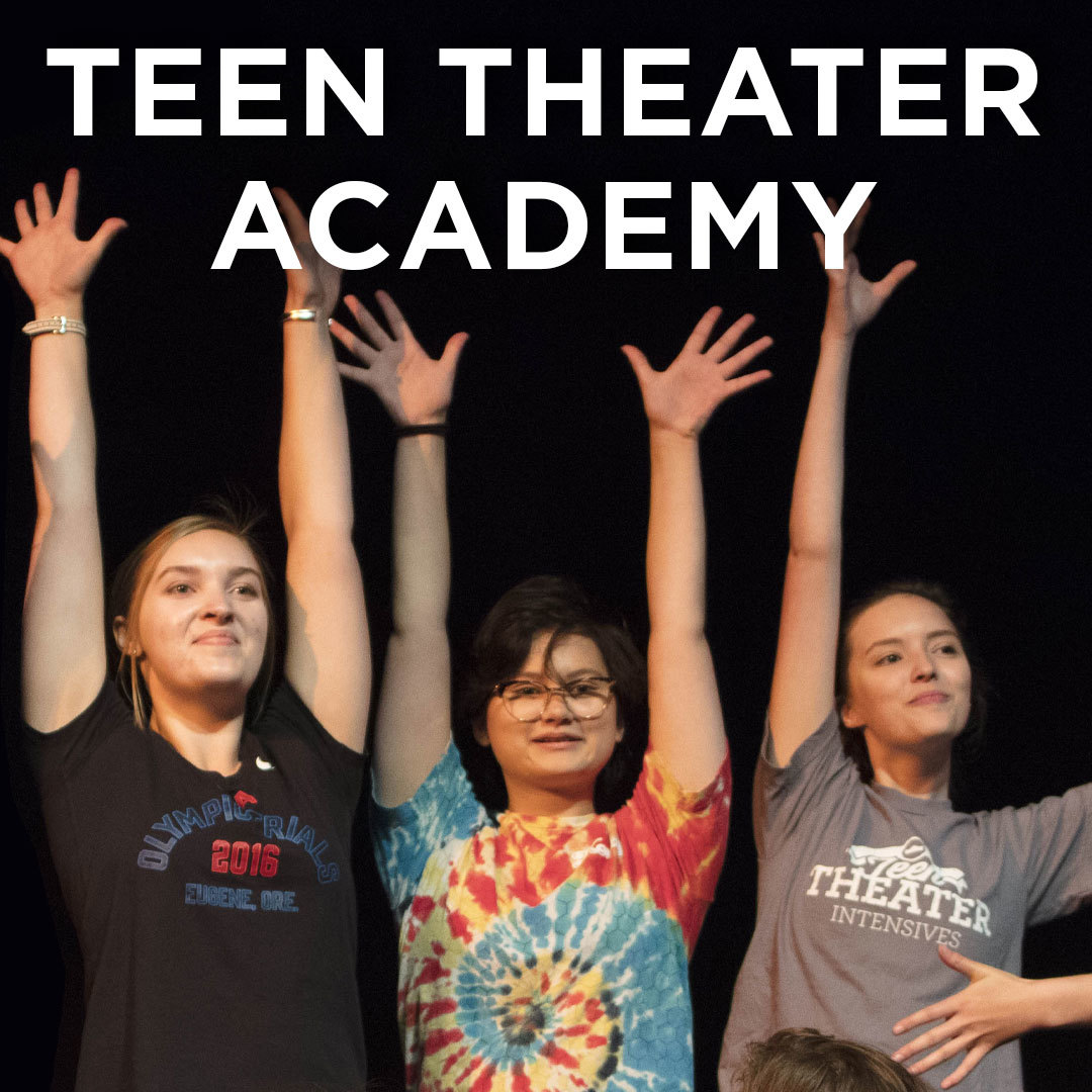 Three Teen Academy students stand together on stage with their arms raised above their heads.