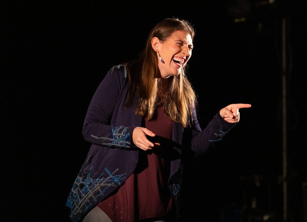 A woman points and laughs to her left.